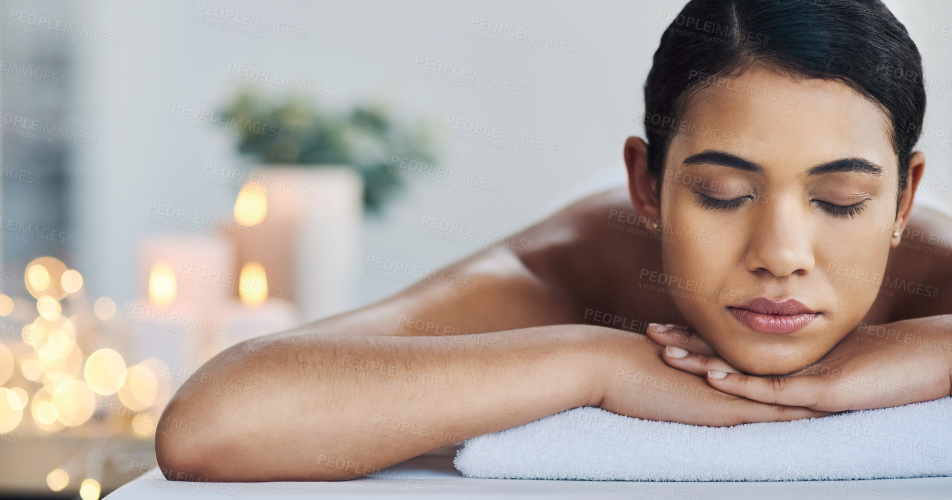 Buy stock photo Shot of a relaxed an cheerful young woman getting a massage indoors at a spa