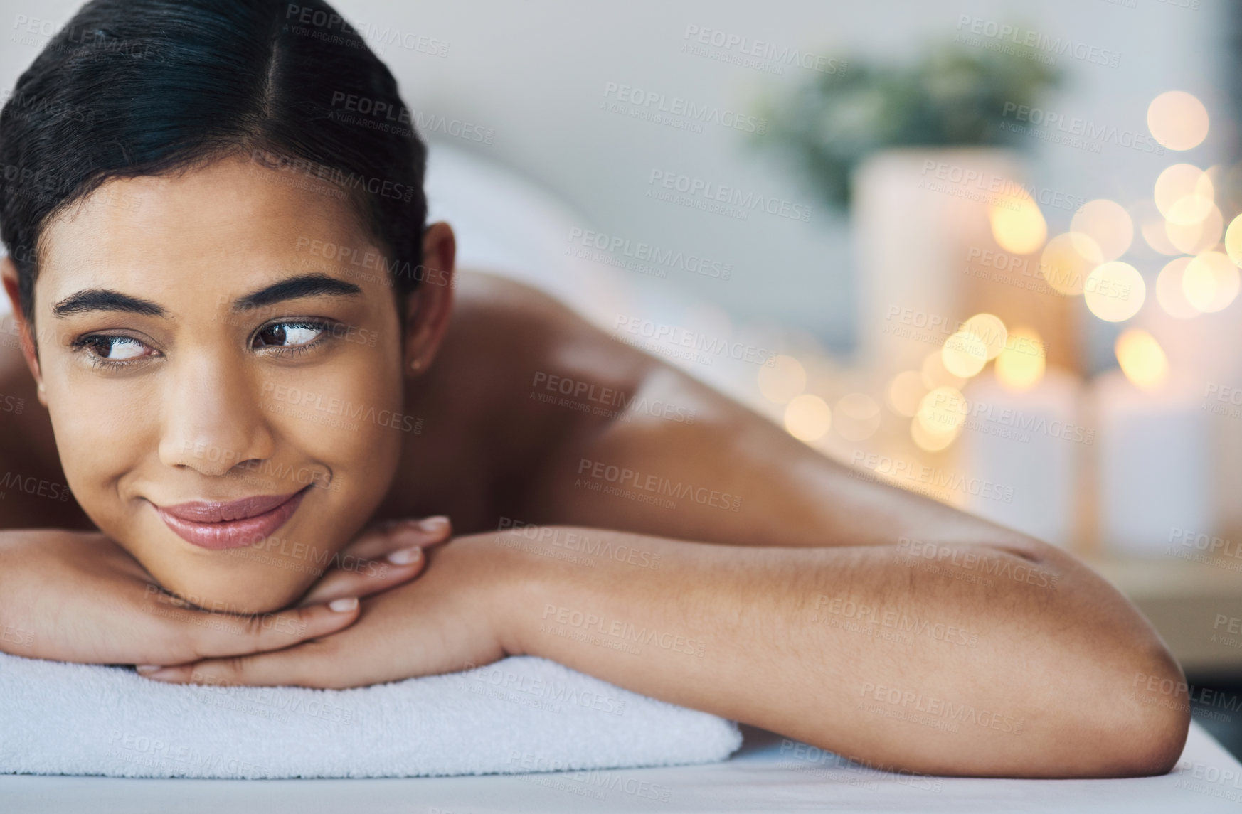 Buy stock photo Shot of a relaxed an cheerful young woman getting a massage indoors at a spa