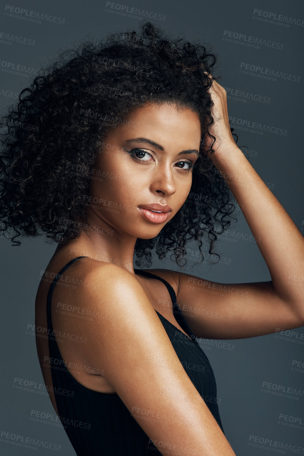 Buy stock photo Studio shot of a beautiful young woman posing against a dark background