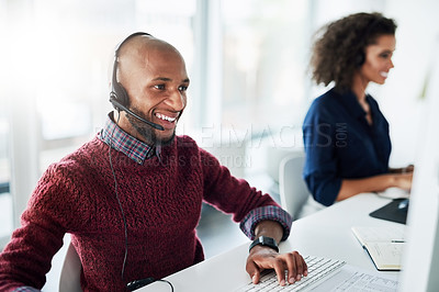 Buy stock photo Cropped shot of a handsome young male call center agent working in his office