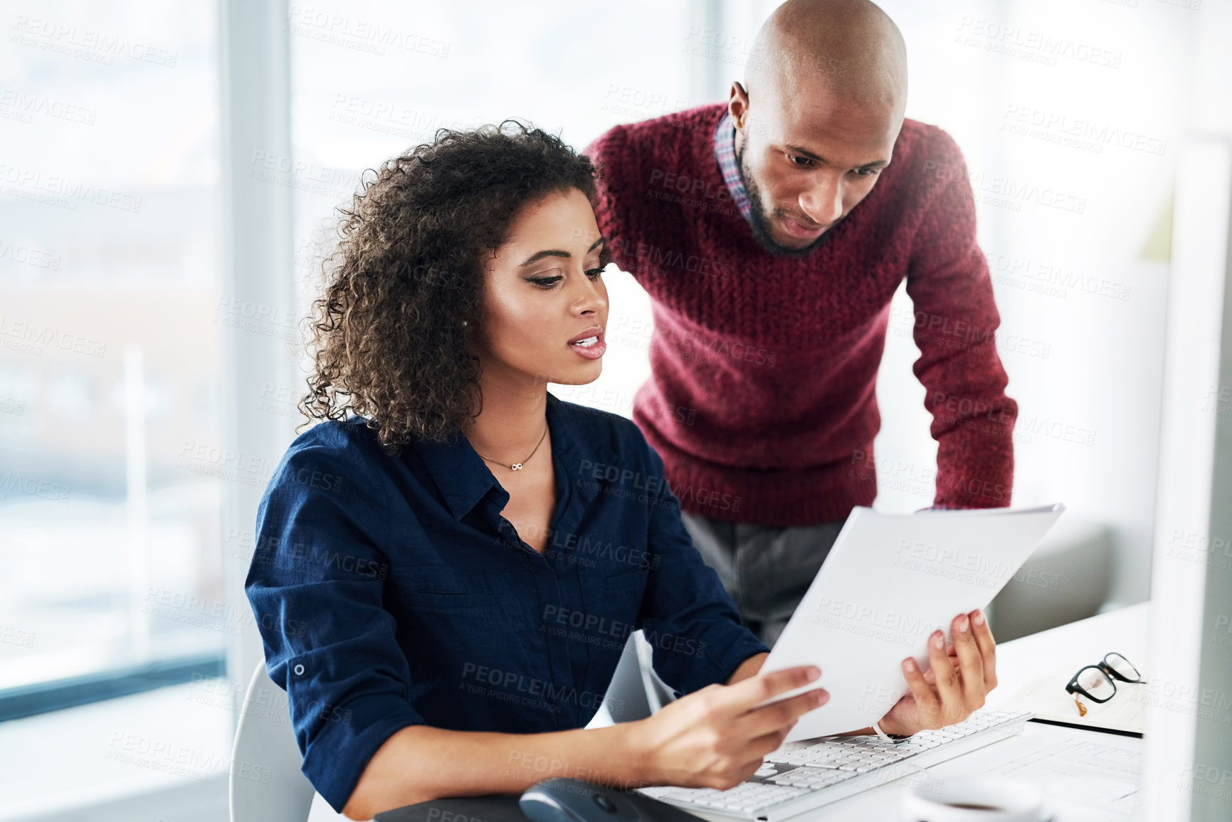 Buy stock photo Cropped shot of a male supervisor helping an attractive young businesswoman while working in their office