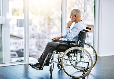 Buy stock photo Shot of a mature man sitting in a wheelchair and looking out the window
