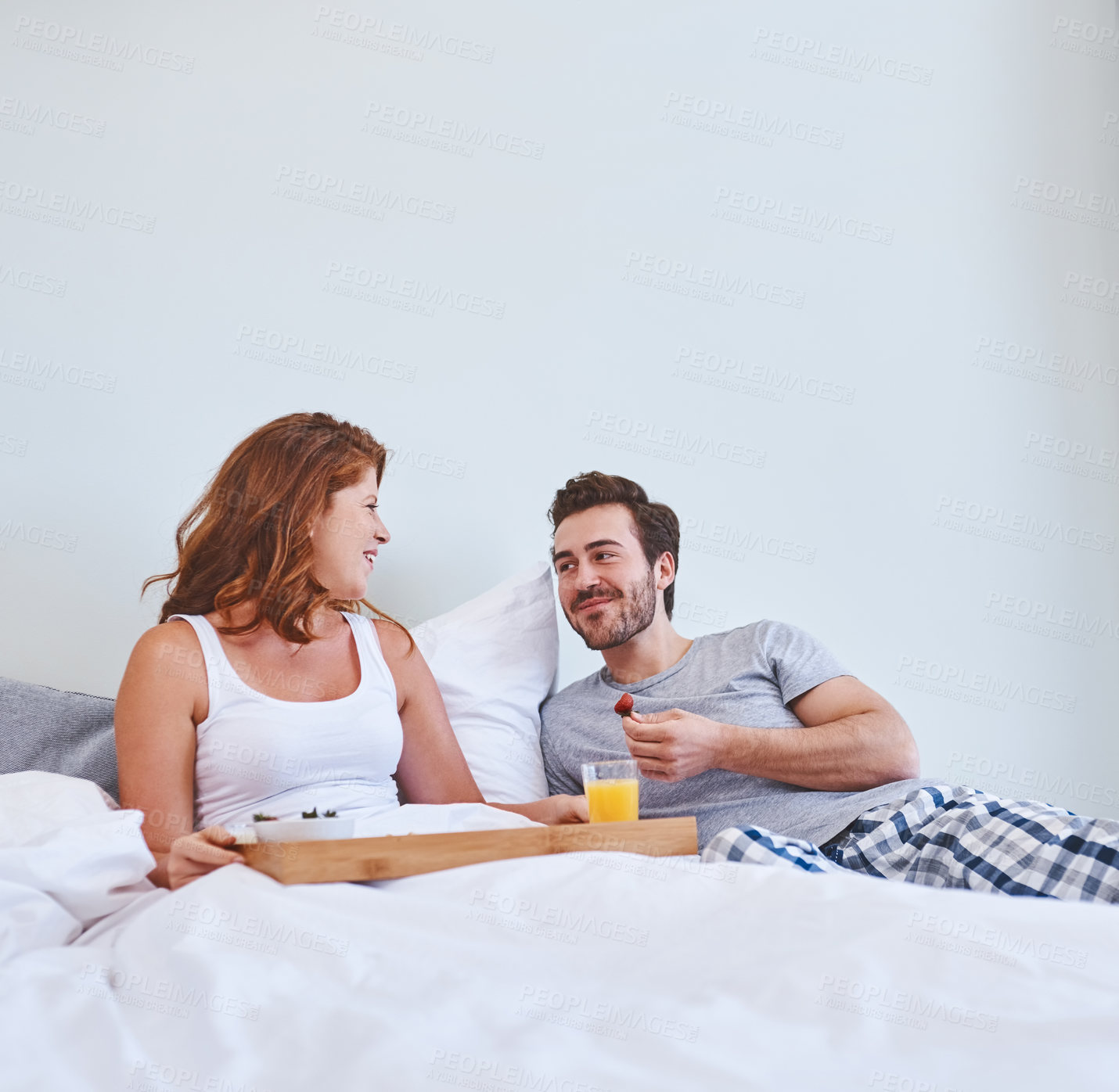 Buy stock photo Breakfast, eating and couple in bed, food and man with meal for woman, birthday and healthy diet in house. Bedroom, happy and surprise for partner, eggs and romantic in morning, nutrition and people