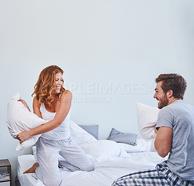 Buy stock photo Shot of a couple having a pillow fight at home