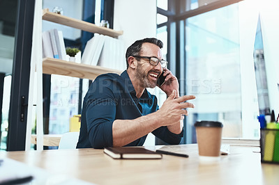 Buy stock photo Shot of a mature businessman talking on his phone while sitting at his desk