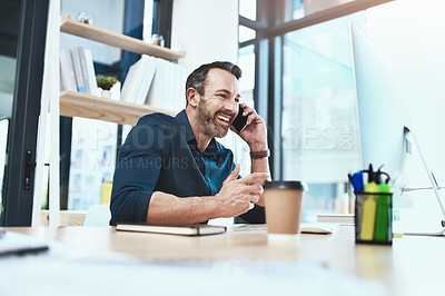 Buy stock photo Shot of a mature businessman talking on his phone while sitting at his desk