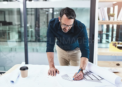 Buy stock photo Shot of a mature male architect working on a design in his office