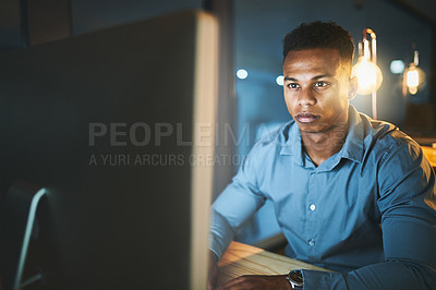 Buy stock photo Cropped shot of a handsome young businessman working late at night in a modern office