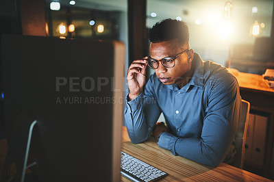 Buy stock photo Cropped shot of a handsome young businessman working late at night in a modern office