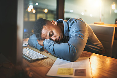 Buy stock photo Cropped shot of a handsome young businessman sleeping at his desk while working late at night in a modern office