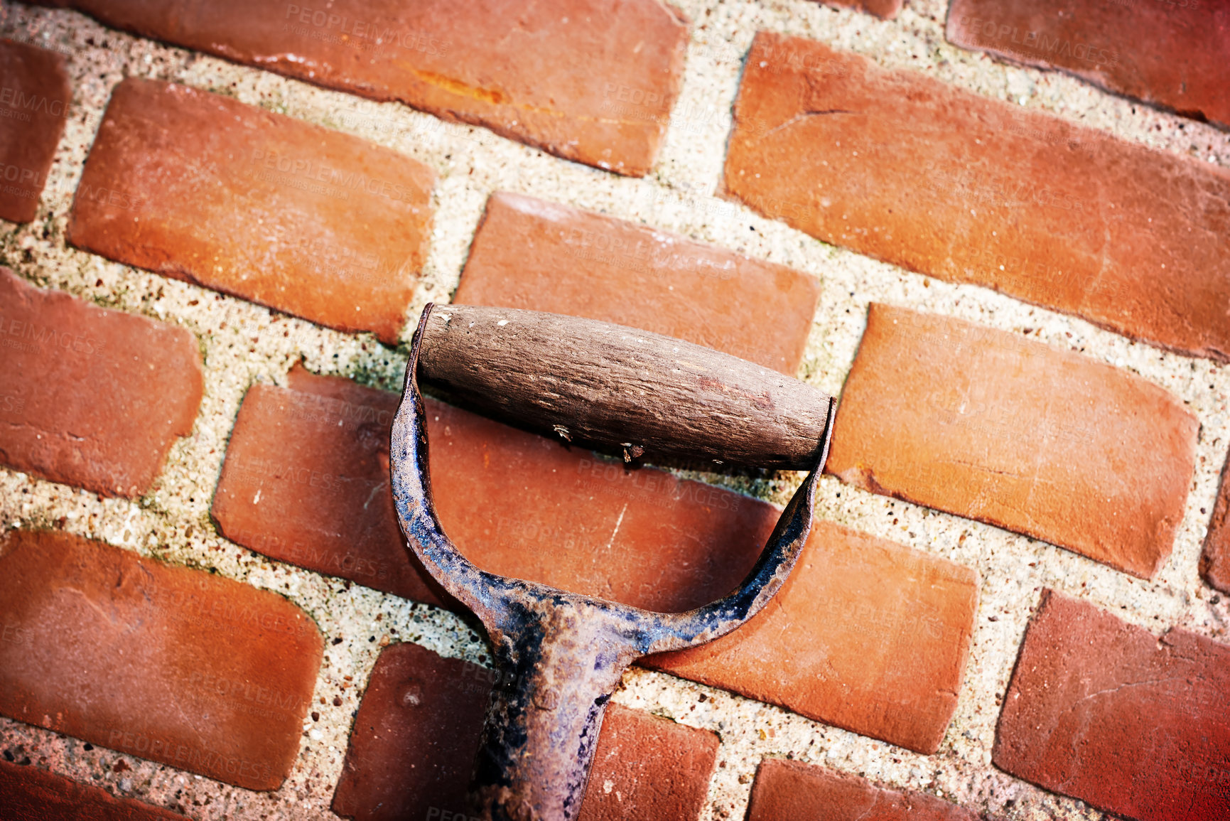 Buy stock photo Closeup of a shovel leaning on a red brick wall with copy space on exterior of a home, house or city building. Texture and detail background of gardening tool against rough architecture construction