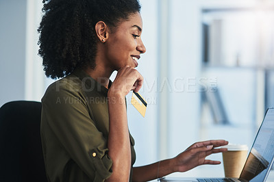 Buy stock photo Shot of a young businesswoman using her laptop and credit card in a modern office