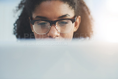 Buy stock photo Shot of a young businesswoman busy working on her laptop in a modern office