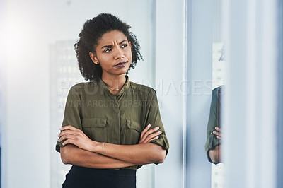 Buy stock photo Shot of a young businesswoman looking out of a window in her office