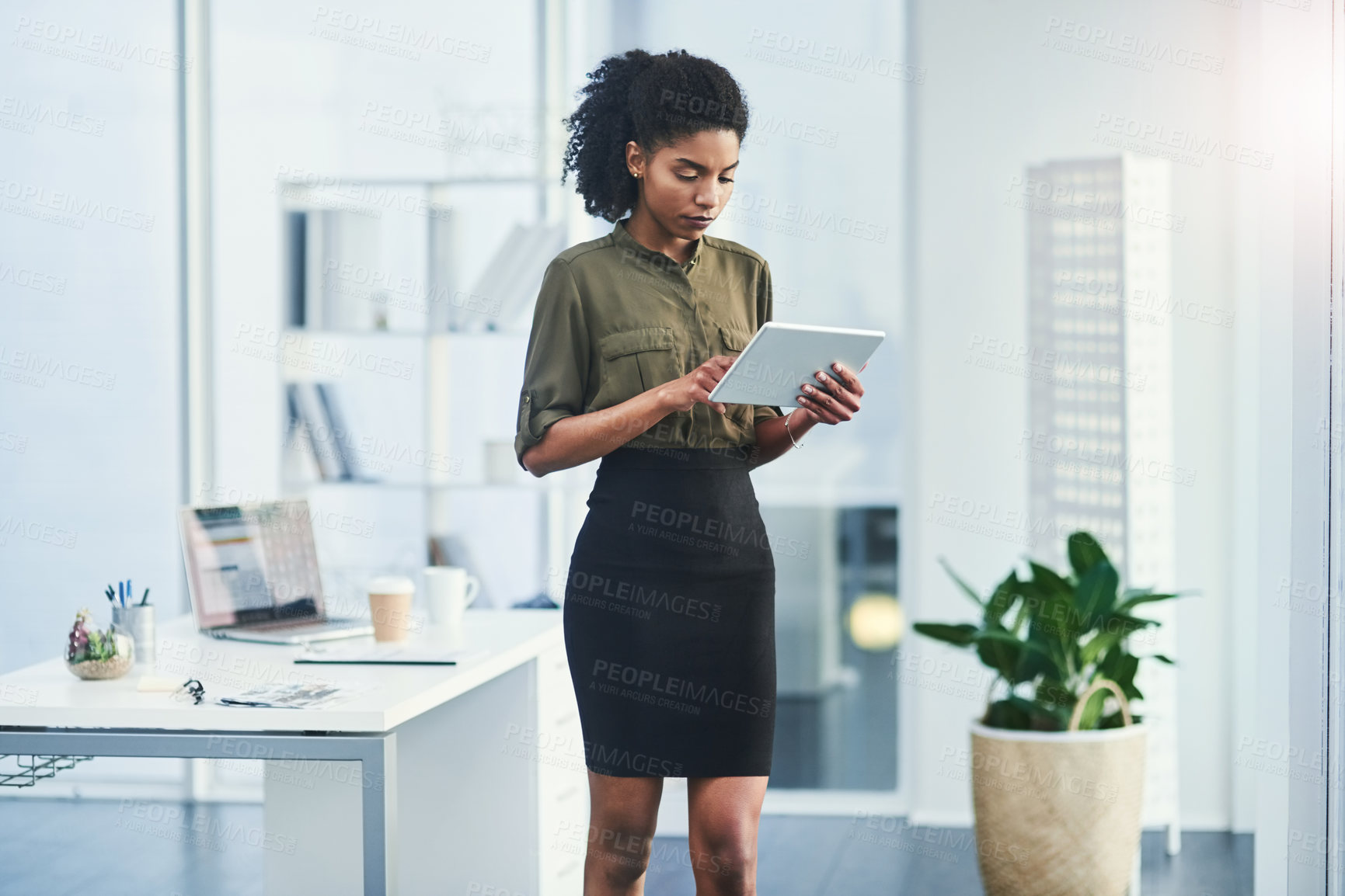 Buy stock photo Shot of a young businesswoman using her digital tablet in a office