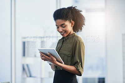 Buy stock photo Shot of a young businesswoman using her digital tablet in a office