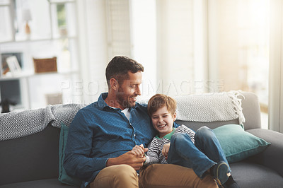 Buy stock photo Father, boy and relax on sofa together in home, bonding and hug for funny conversation. Daddy, son and happy family playing in living room for joke, talk and embrace for security in relationship