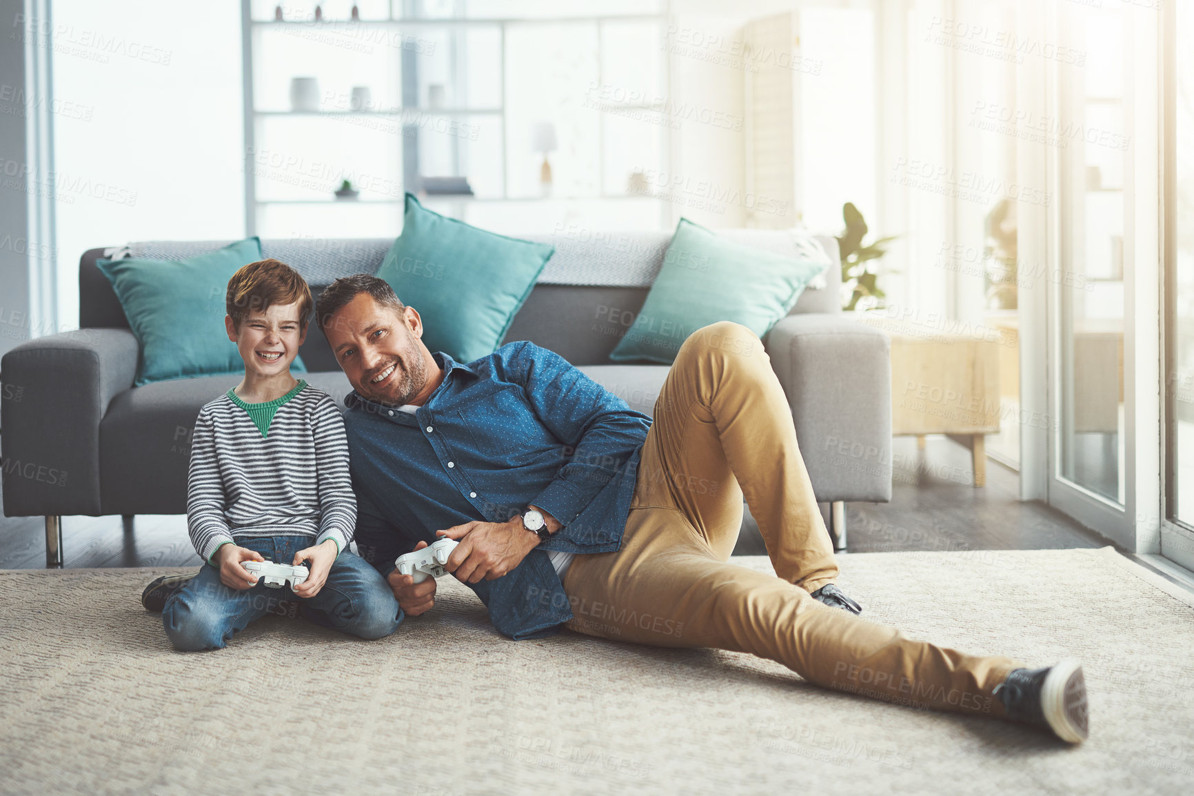 Buy stock photo Happy father, portrait and playing games with child for entertainment or bonding on floor at home. Dad, son or kid with smile and enjoying esports or fun on console together with controller at house