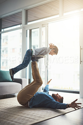 Buy stock photo Flying, playing and dad with child in home for bonding, happy relationship and relax in living room. Family, playful and father and young boy have fun for airplane games, support and balance on floor