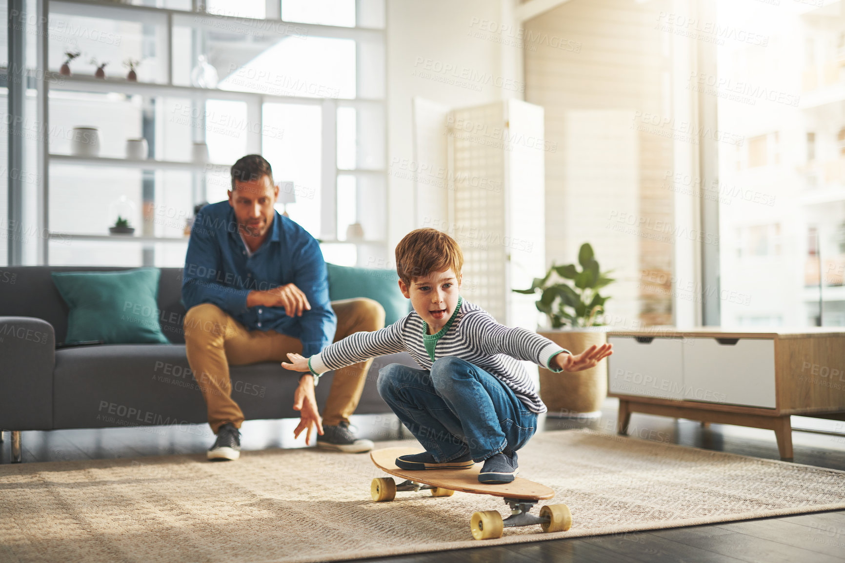 Buy stock photo Learning, home and boy on skateboard with dad for balance, bonding or fun in living room. Progress, playing and child with parent or father on board for teaching skating skills or growth development