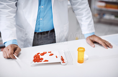 Buy stock photo Shot of a pharmacist counting medication in a drugstore