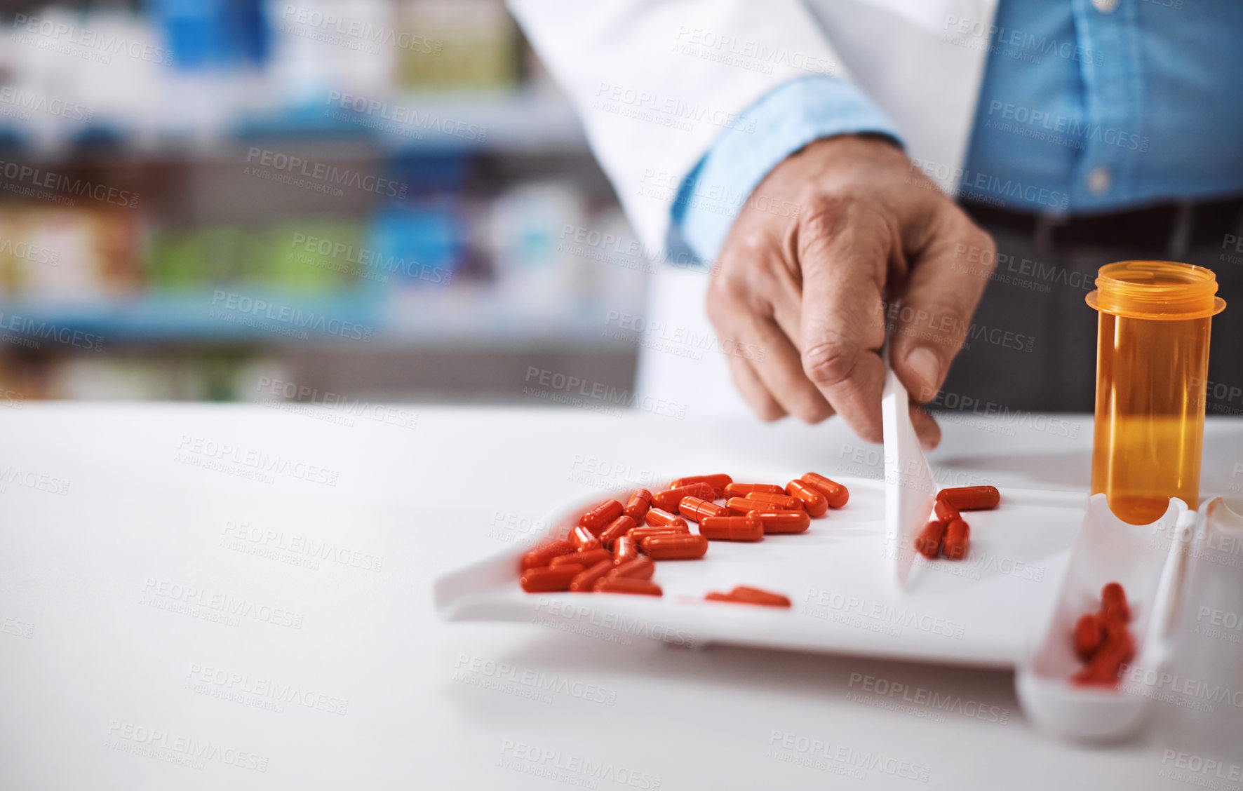 Buy stock photo Shot of a pharmacist counting medication in a drugstore