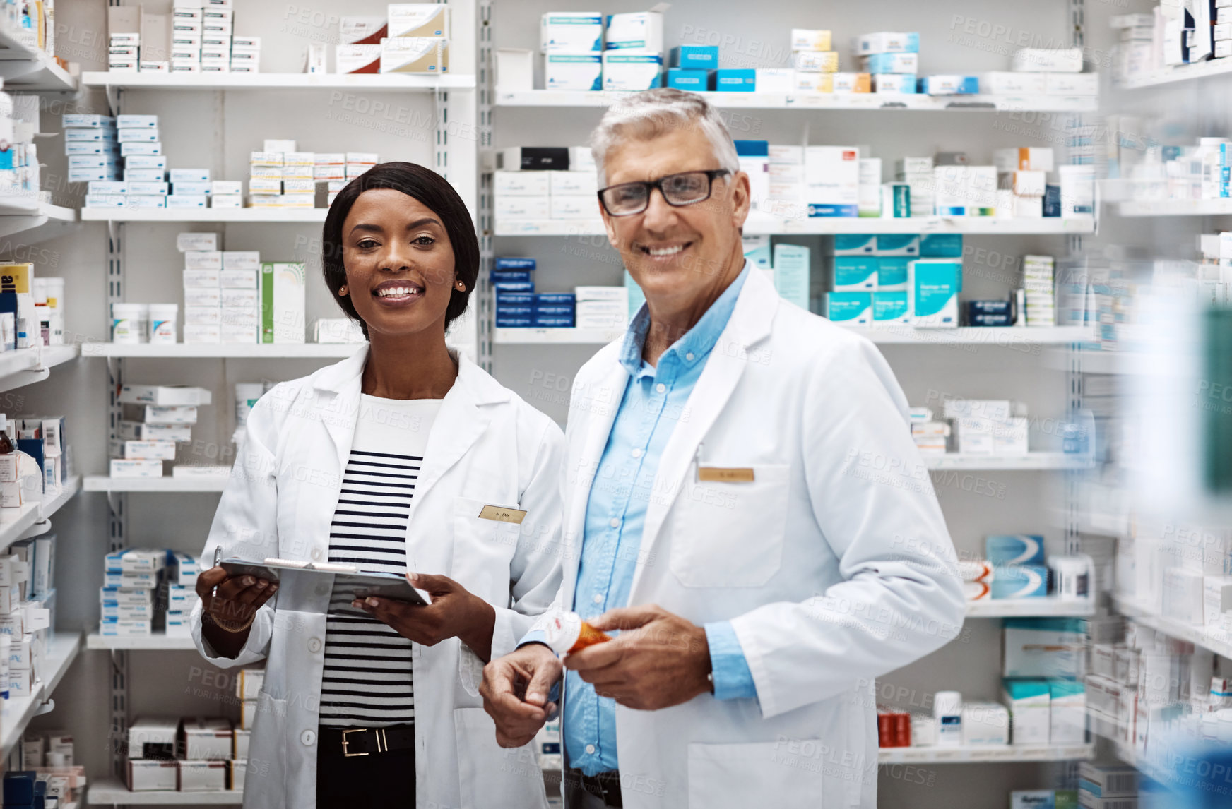 Buy stock photo Shot of two pharmacists working together in a drugstore