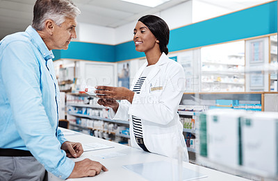 Buy stock photo Shot of a female pharmacist assisting a customer in a drugstore