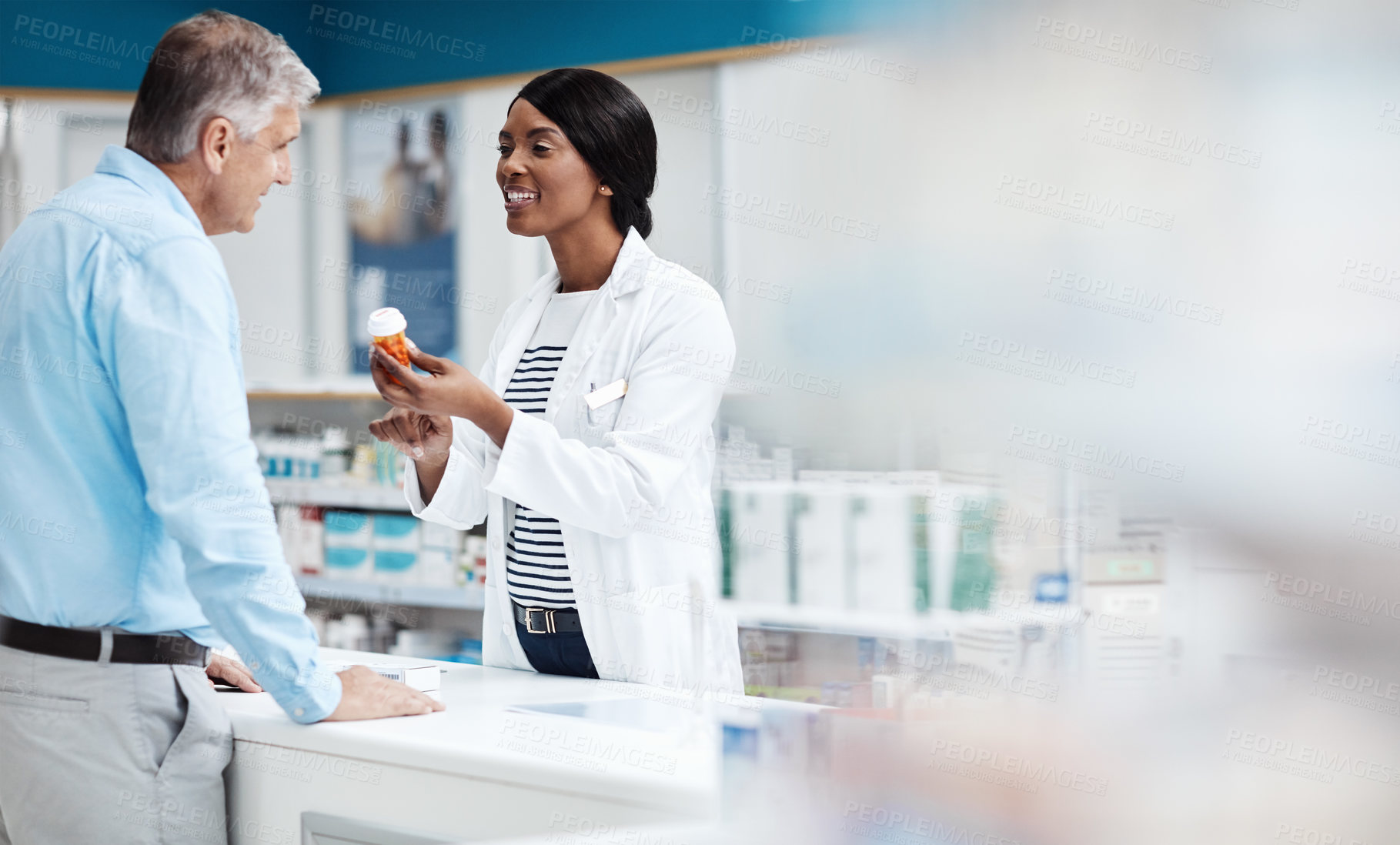 Buy stock photo Shot of a female pharmacist assisting a customer in a drugstore