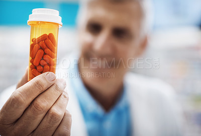 Buy stock photo Cropped shot of a pharmacist holding up capsules