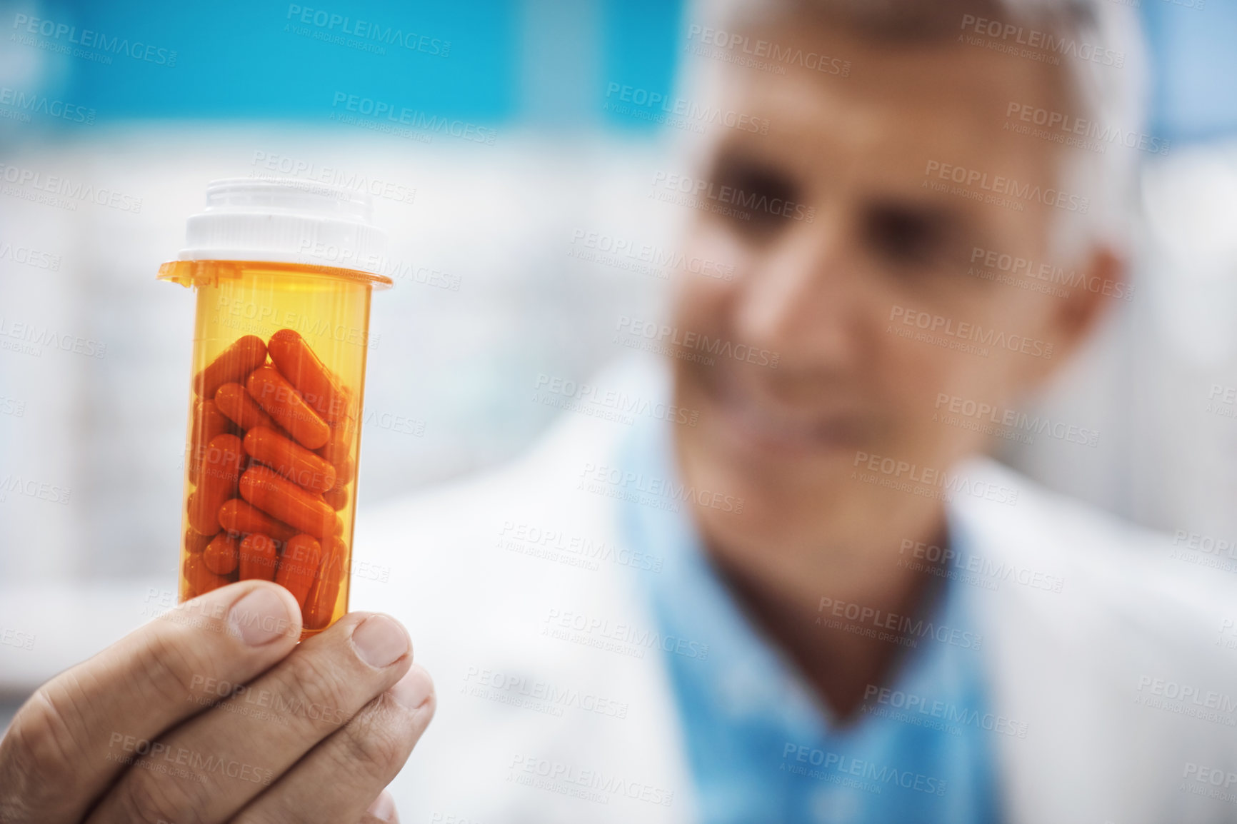 Buy stock photo Cropped shot of a pharmacist holding up capsules