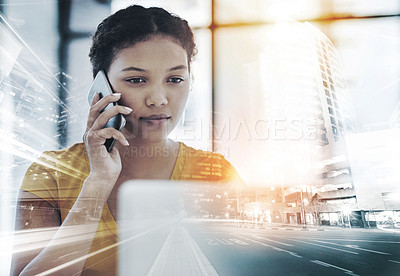 Buy stock photo Shot of a young designer talking on a cellphone while working on a laptop in an office