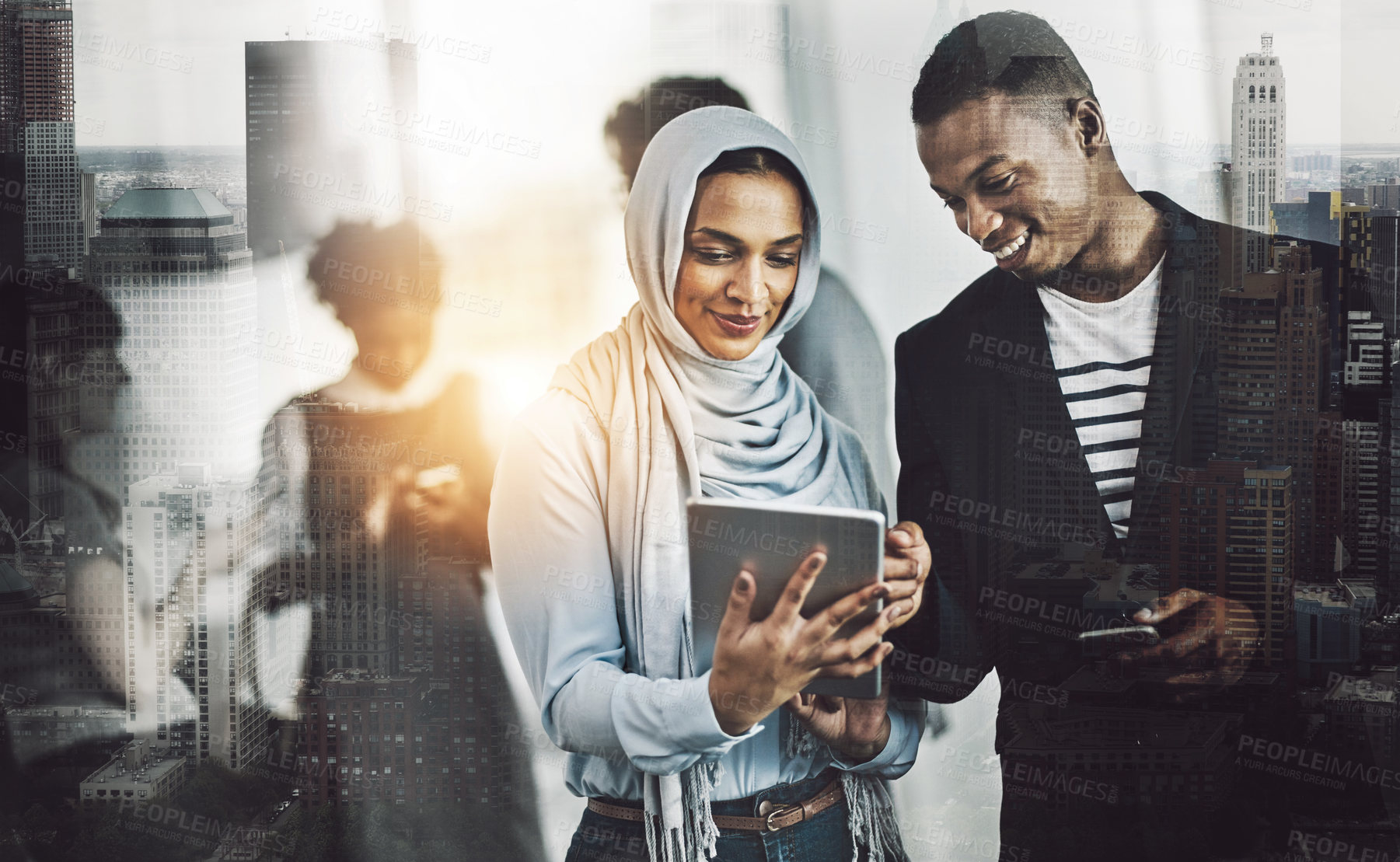 Buy stock photo Shot of a group of young cheerful businesspeople browsing on digital devices while working together in the office at work