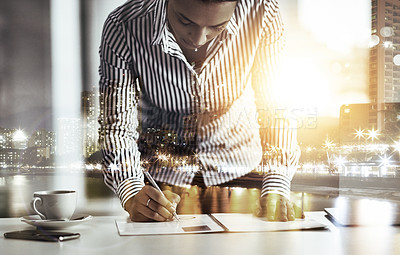 Buy stock photo Shot of a young businesswoman writing notes on a document in an office