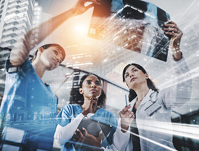 Buy stock photo Cropped shot of a group of doctors discussing the results of an X-ray in a hospital