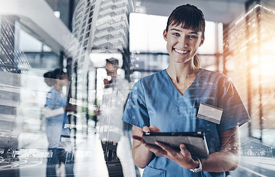 Buy stock photo Cropped shot of an attractive young female doctor using a tablet in a hospital with colleagues in the background