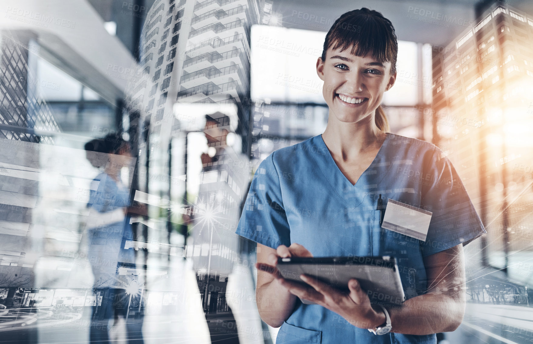 Buy stock photo Cropped shot of an attractive young female doctor using a tablet in a hospital with colleagues in the background