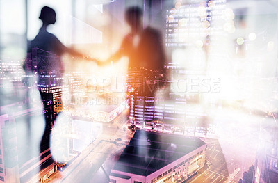 Buy stock photo Defocused shot of two businesspeople shaking hands in an office