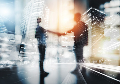 Buy stock photo Defocused shot of two businesspeople shaking hands in an office