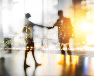Buy stock photo Defocused shot of two unrecognizable businesspeople shaking hands in an office