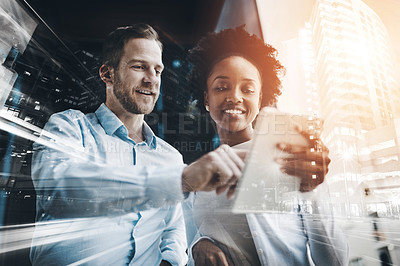 Buy stock photo Cropped shot of two coworkers using a digital tablet while standing on a balcony