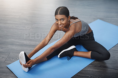 Buy stock photo Shot of a beautiful young woman smiling while sitting down and doing stretching exercises on her gym mat at home