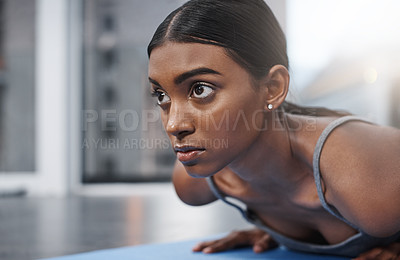 Buy stock photo Close up shot of an attractive young woman busy exercising on her gym mat at home