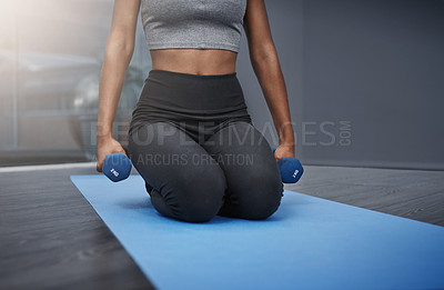 Buy stock photo Cropped shot of an unrecognizable young woman on her knees holding dumbbells while exercising on her gym mat at home