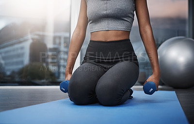 Buy stock photo Cropped shot of an unrecognizable young woman on her knees holding dumbbells while exercising on her gym mat at home