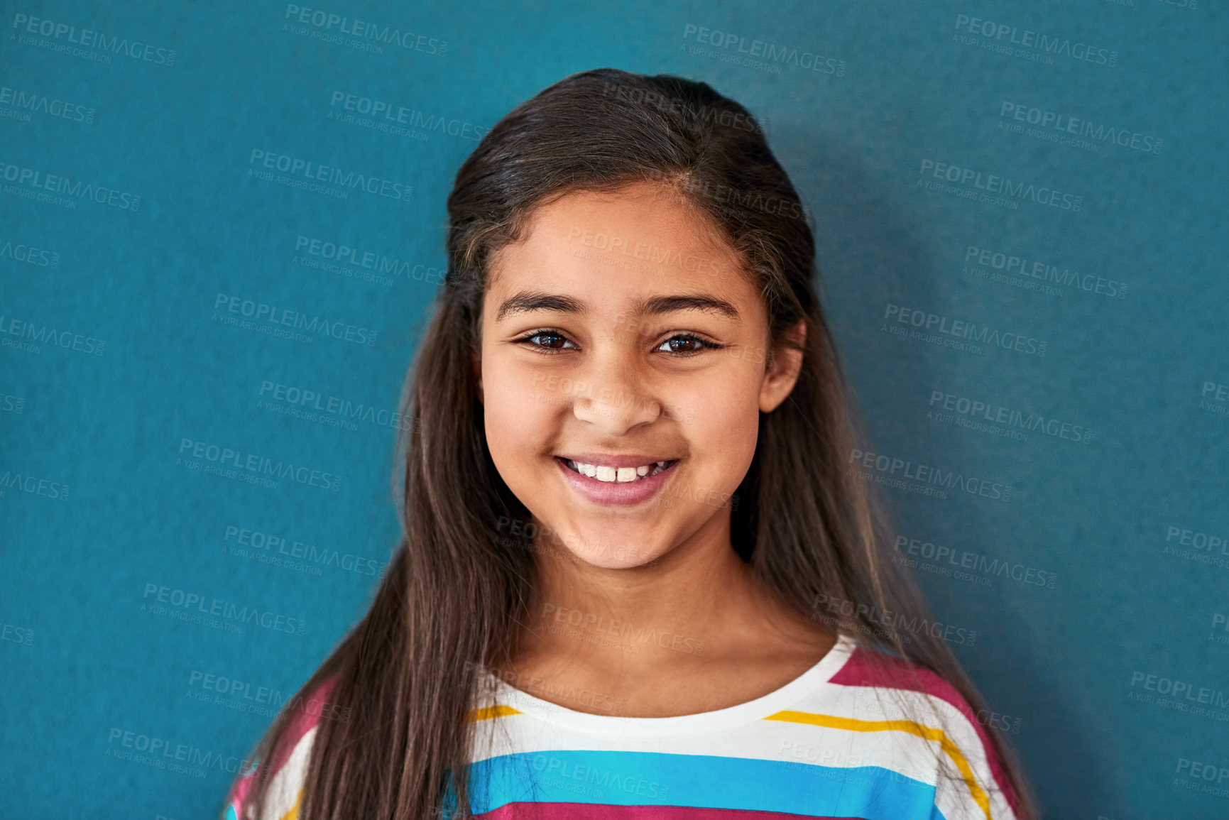 Buy stock photo Girl, child and portrait with happiness in studio, smile for education in New York City. Female student, elementary grade and cheerful for knowledge in classroom, back to school on blue background