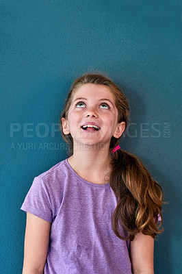 Buy stock photo Studio shot of an adorable little girl looking amazed and thoughtful against a blue background