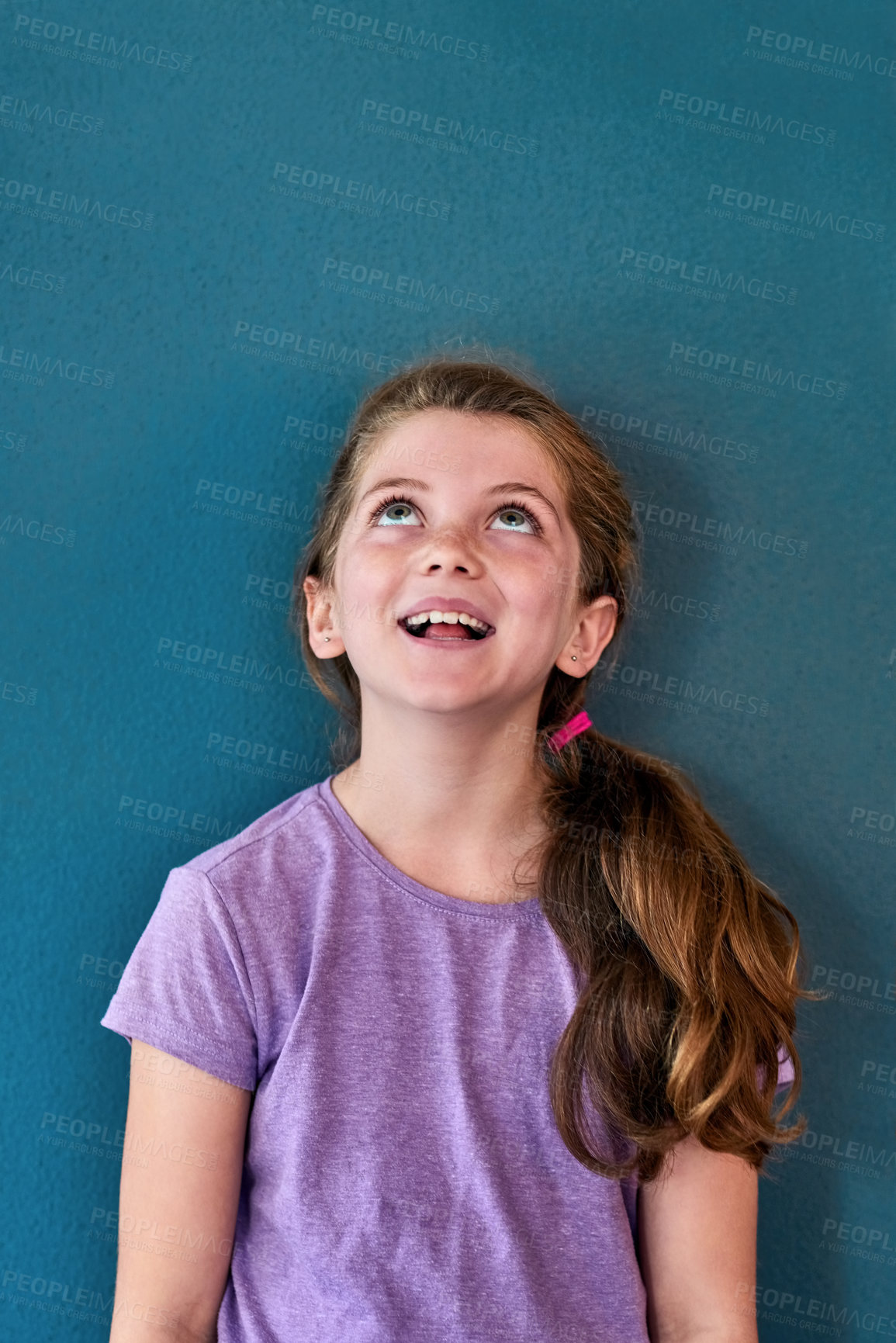 Buy stock photo Studio shot of an adorable little girl looking amazed and thoughtful against a blue background