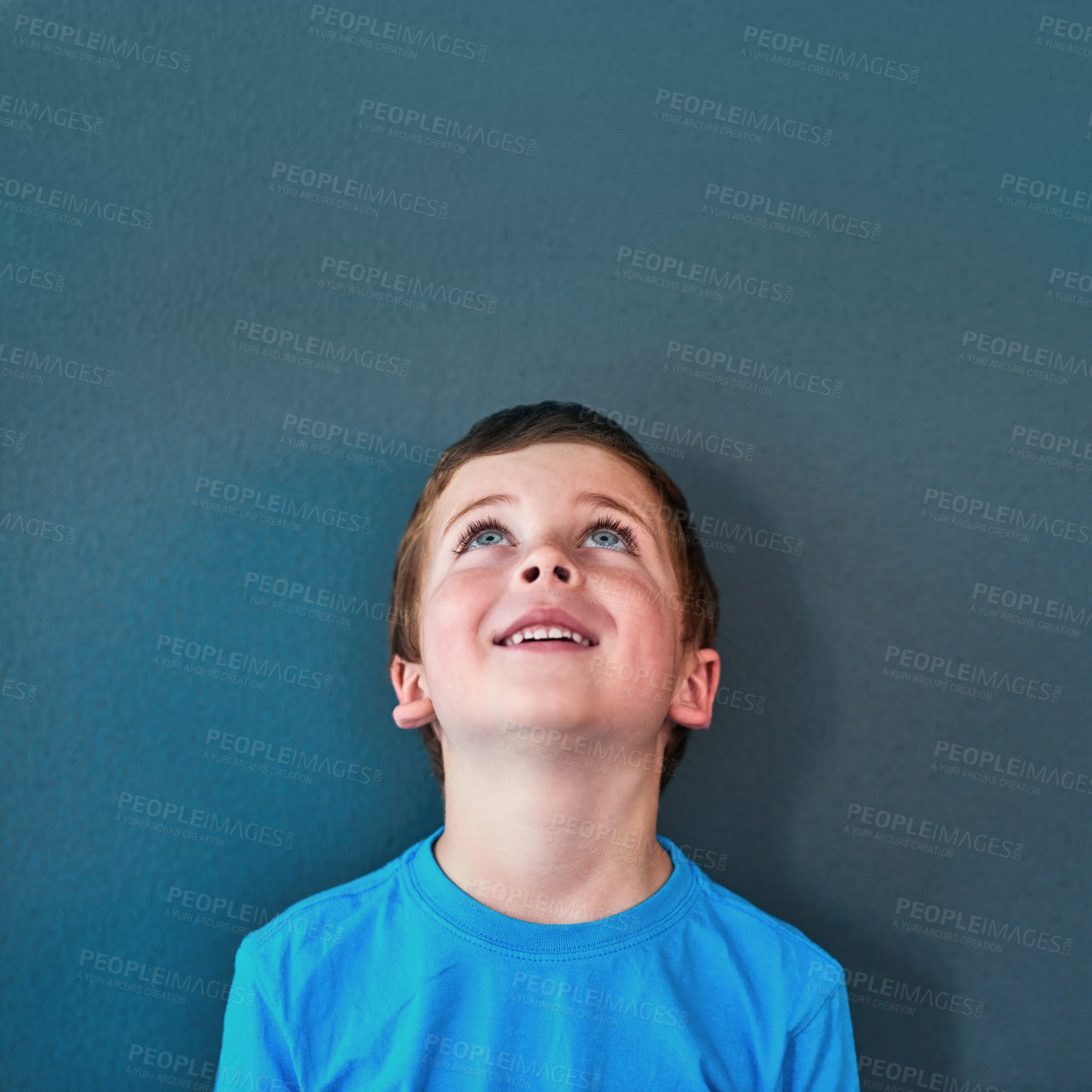 Buy stock photo Excited, happy and child looking up in studio for omg news, opinion and feedback on blue background. Mockup space, surprise and face of isolated young boy with announcement, information and deal