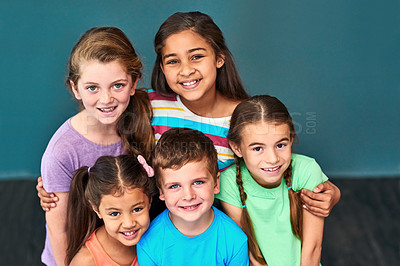 Buy stock photo Friends, happy and portrait of children hug on blue background for back to school, education and academy. Students, youth and group of kids smile for learning, scholarship and diversity in studio